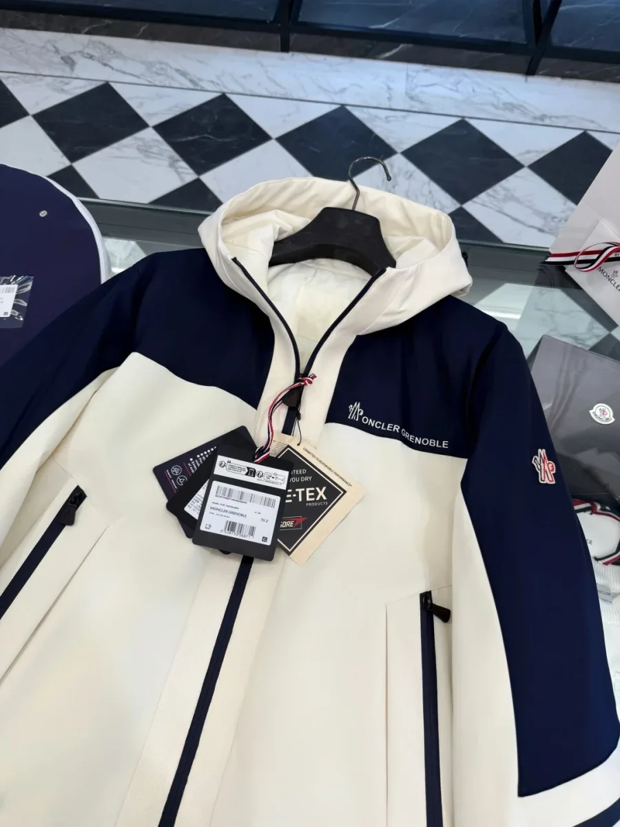 Верхняя часть пуховика Moncler Grenoble с капюшоном и бирками крупным планом
