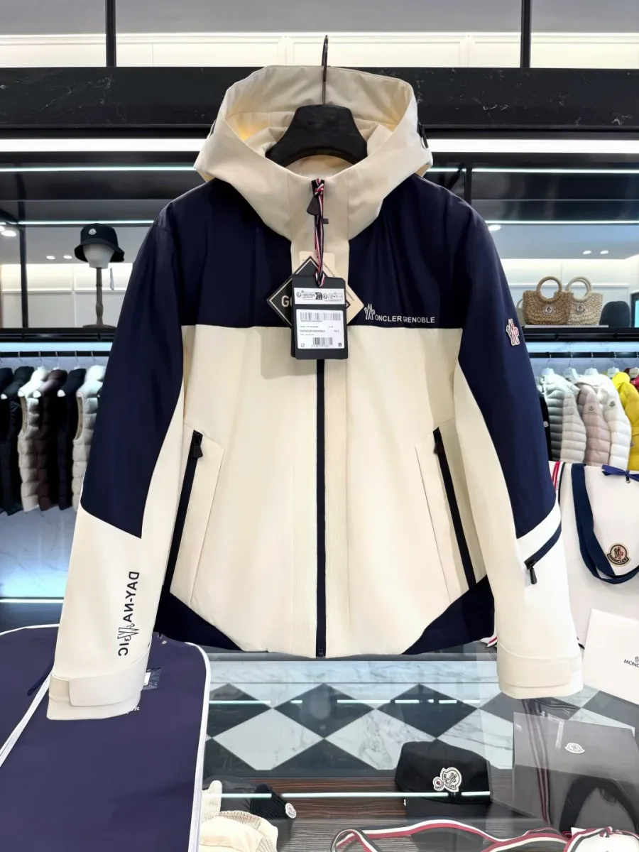 Кремово-синяя куртка Moncler Grenoble на вешалке на светлом фоне, вид спереди