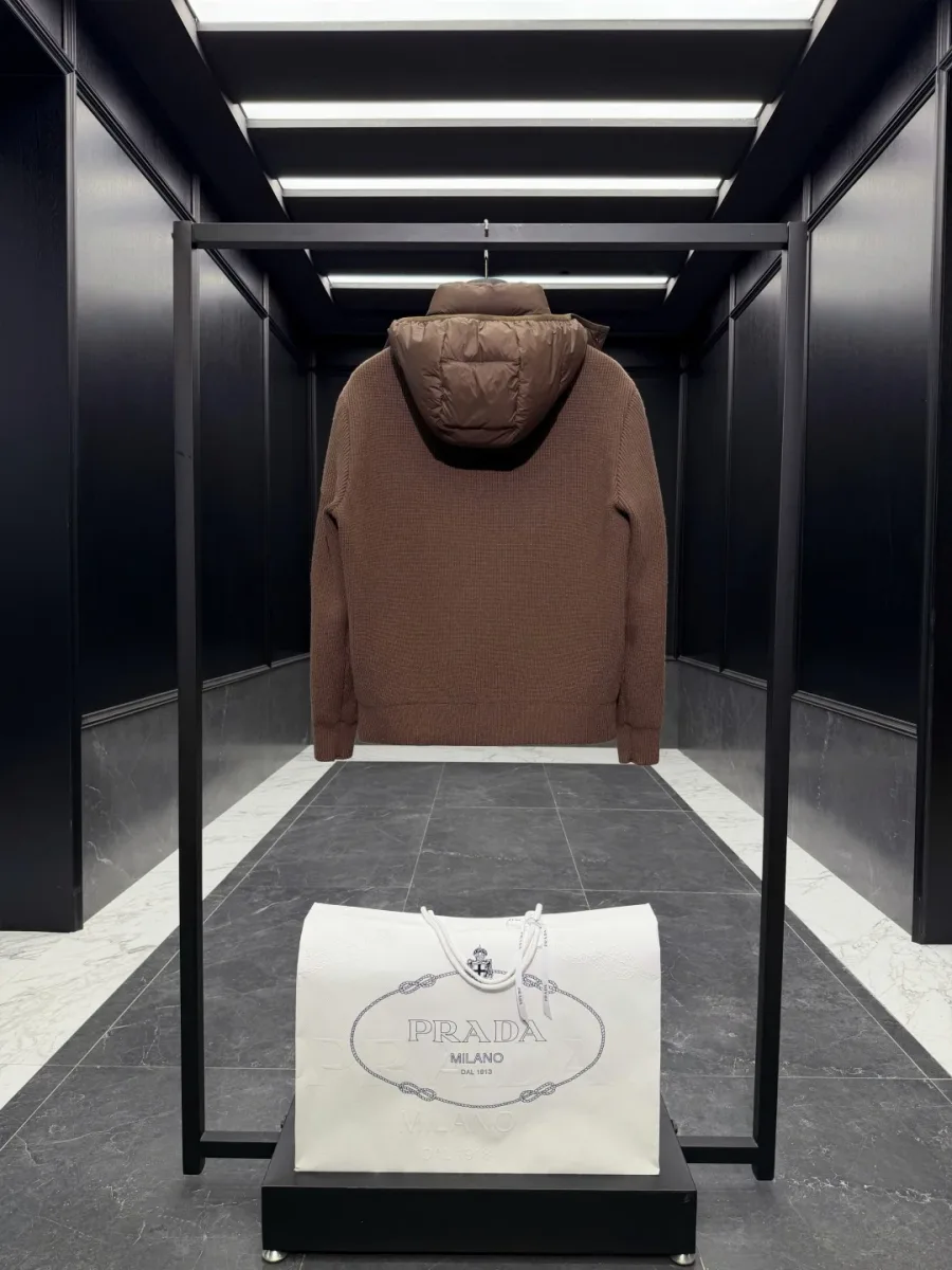 Коричневый пуховик Prada на рейле, вид сзади: полностью вязаная спинка в рубчик и стёганый капюшон