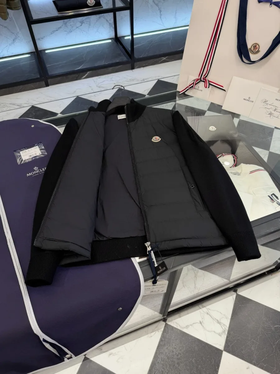 Чёрная куртка Moncler с расстёгнутой молнией, вид подкладки на столе