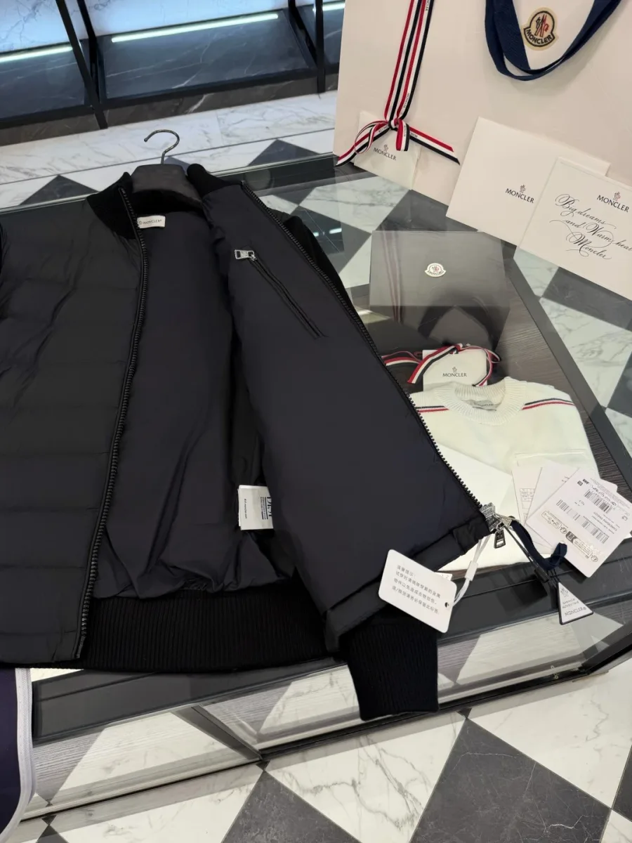 Внутренняя сторона чёрной куртки Moncler с молнией и фирменными бирками
