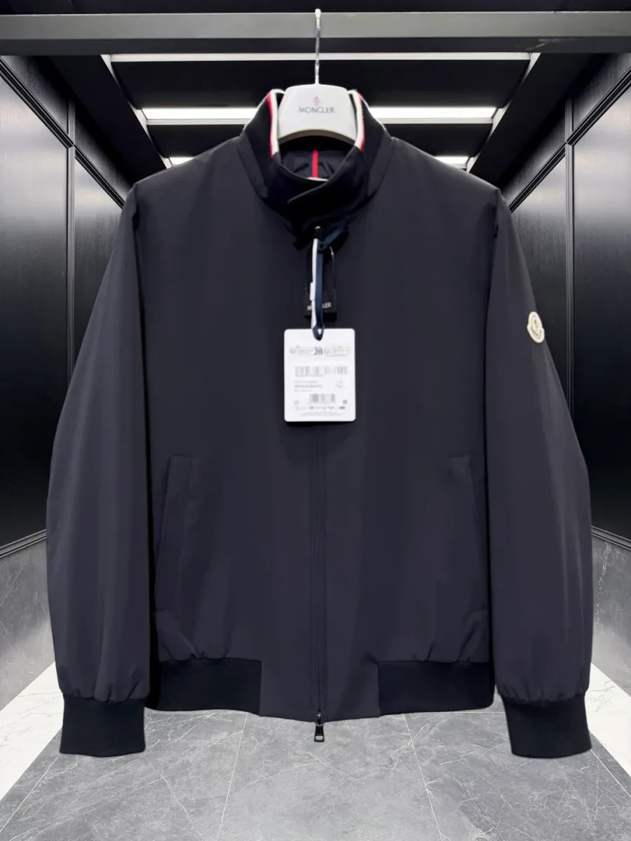Крупный план передней части чёрной куртки-бомбера Moncler Reppe с триколором на воротнике