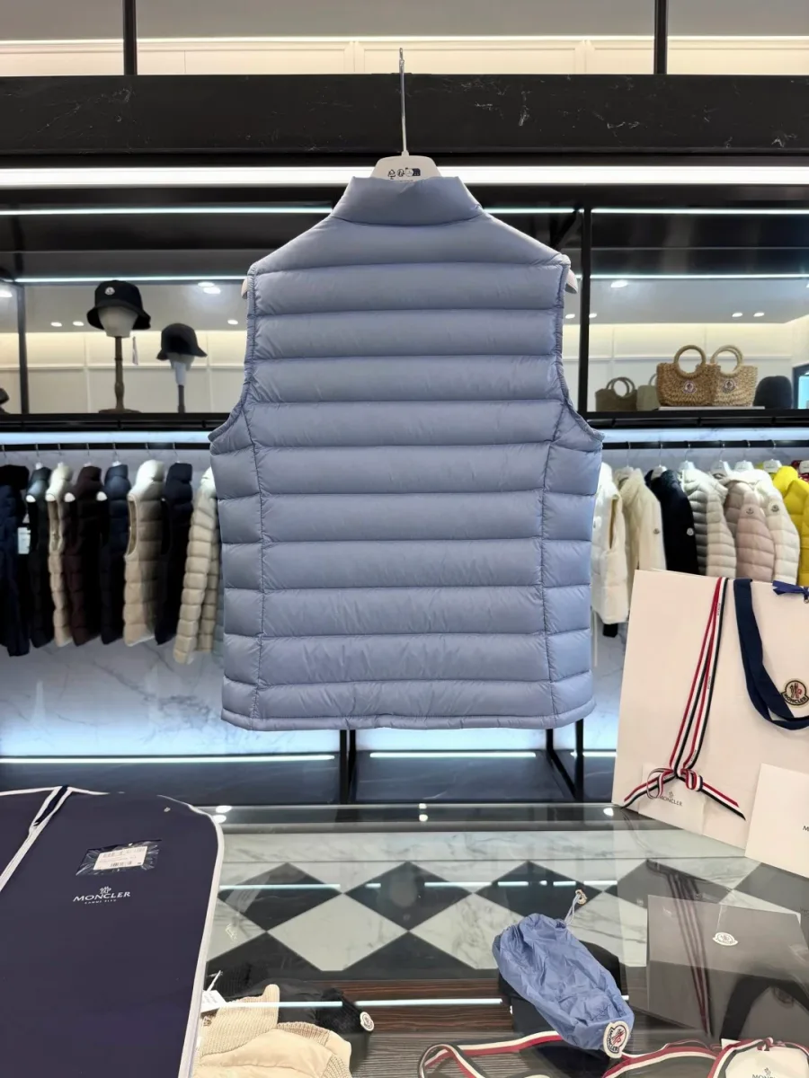 Спинка светло-голубого стеганого жилета Moncler на плечиках