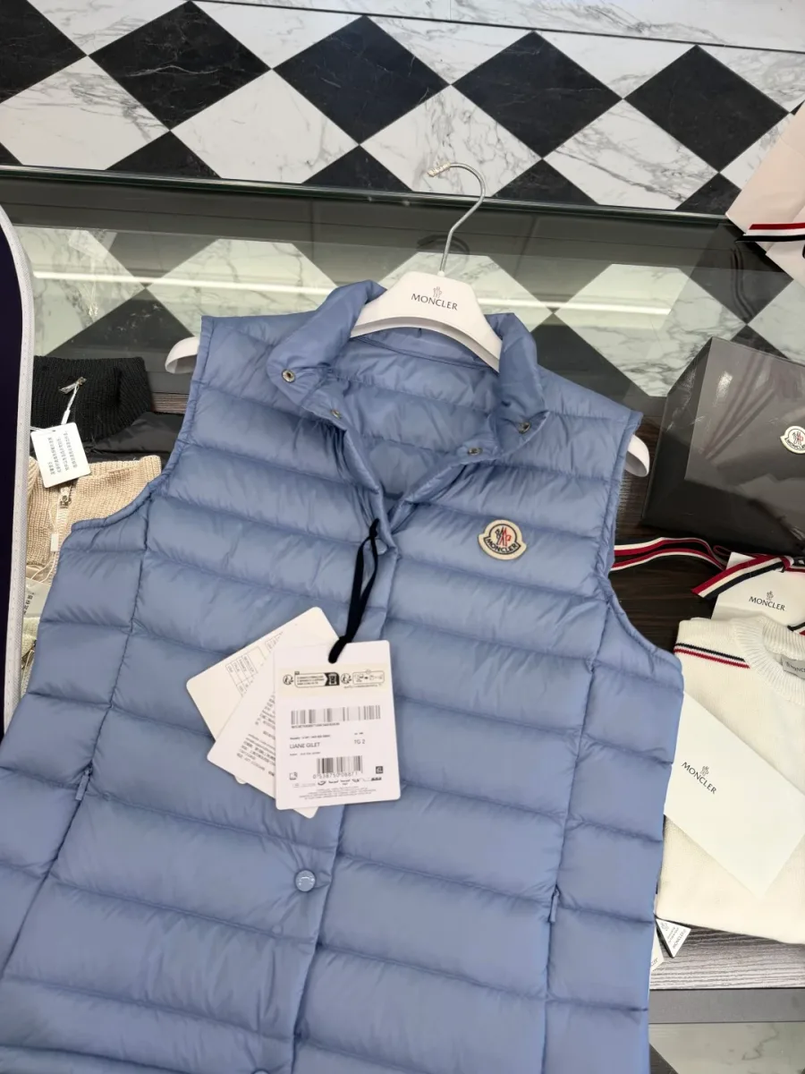Верхняя часть светло-голубого жилета Moncler с логотипом и навесными ярлыками