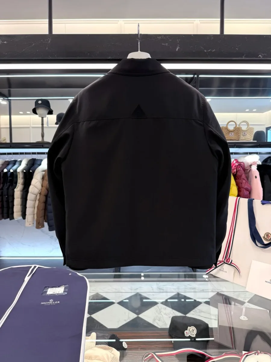 Чёрная куртка Moncler на вешалке, вид со спины со стороны кокетки.