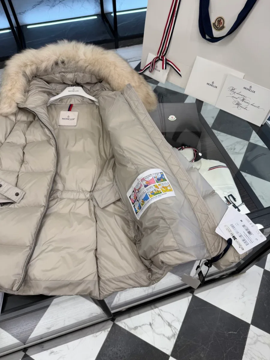 Внутренняя бирка и фирменный комикс пуховика Moncler крупным планом