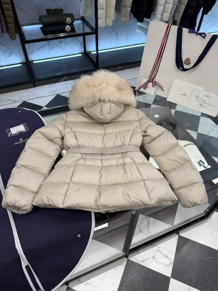Вид сзади бежевого пуховика Moncler в горизонтальной раскладке на столе