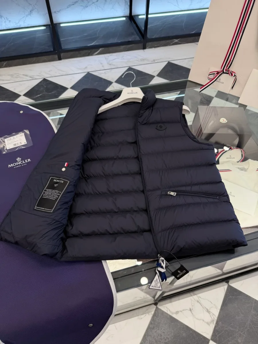 Раскрытый тёмно-синий жилет Moncler с внутренним карманом на молнии и чёрной нашивкой внутри