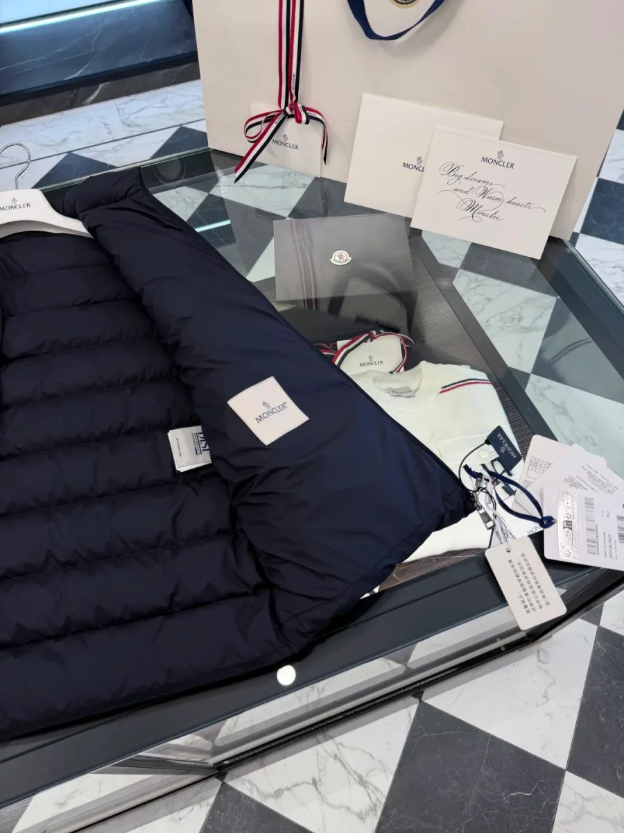 Детали внутренней отделки и тканевая этикетка тёмно-синего жилета Moncler, крупный план