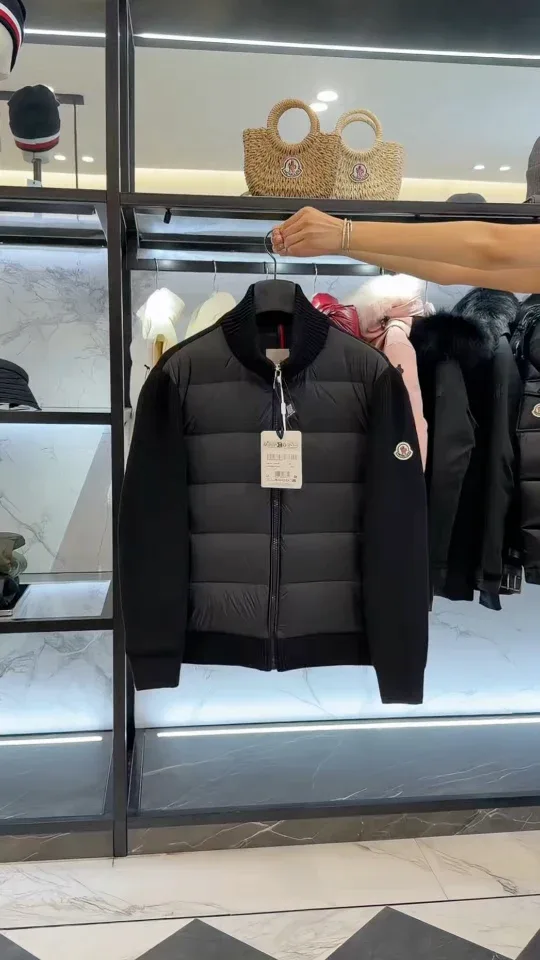Чёрный кардиган Moncler на вешалке на фоне витрины магазина