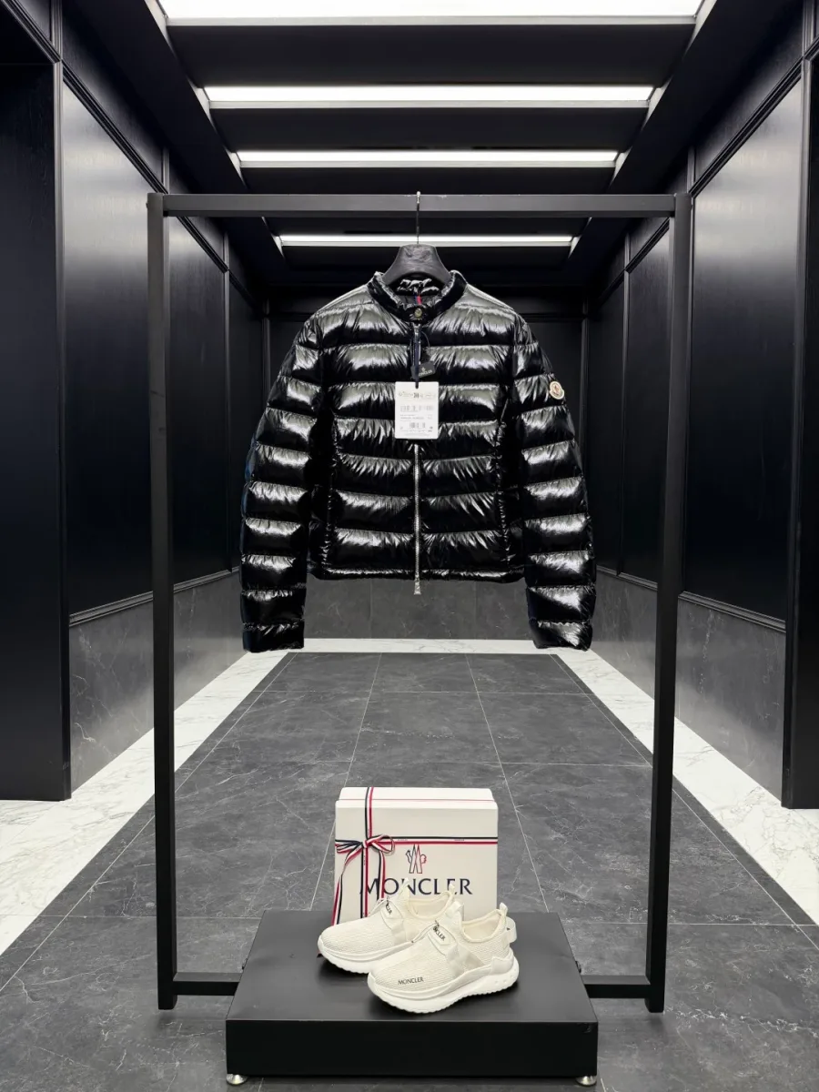Чёрный укороченный пуховик Moncler на вешалке в интерьере, фронтальный вид