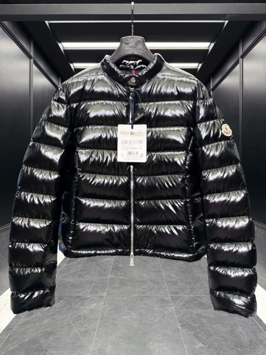 Чёрный пуховик Moncler с воротником-стойкой и навесными бирками, вид спереди