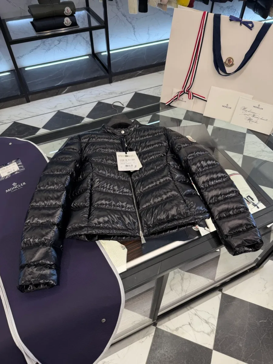 Чёрный пуховик Moncler в расправленном виде на столе, вид спереди