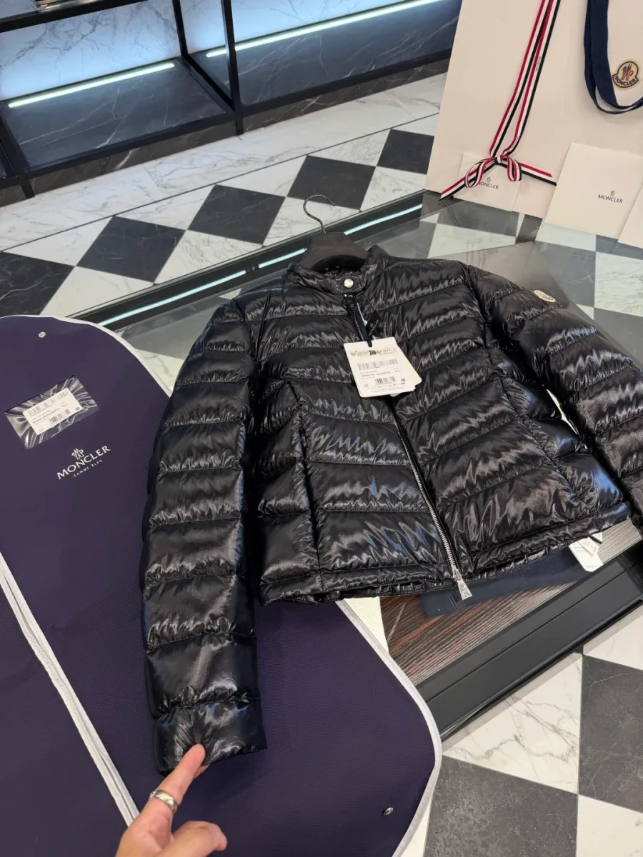 Чёрный пуховик Moncler на стеклянной витрине с демонстрацией рукава