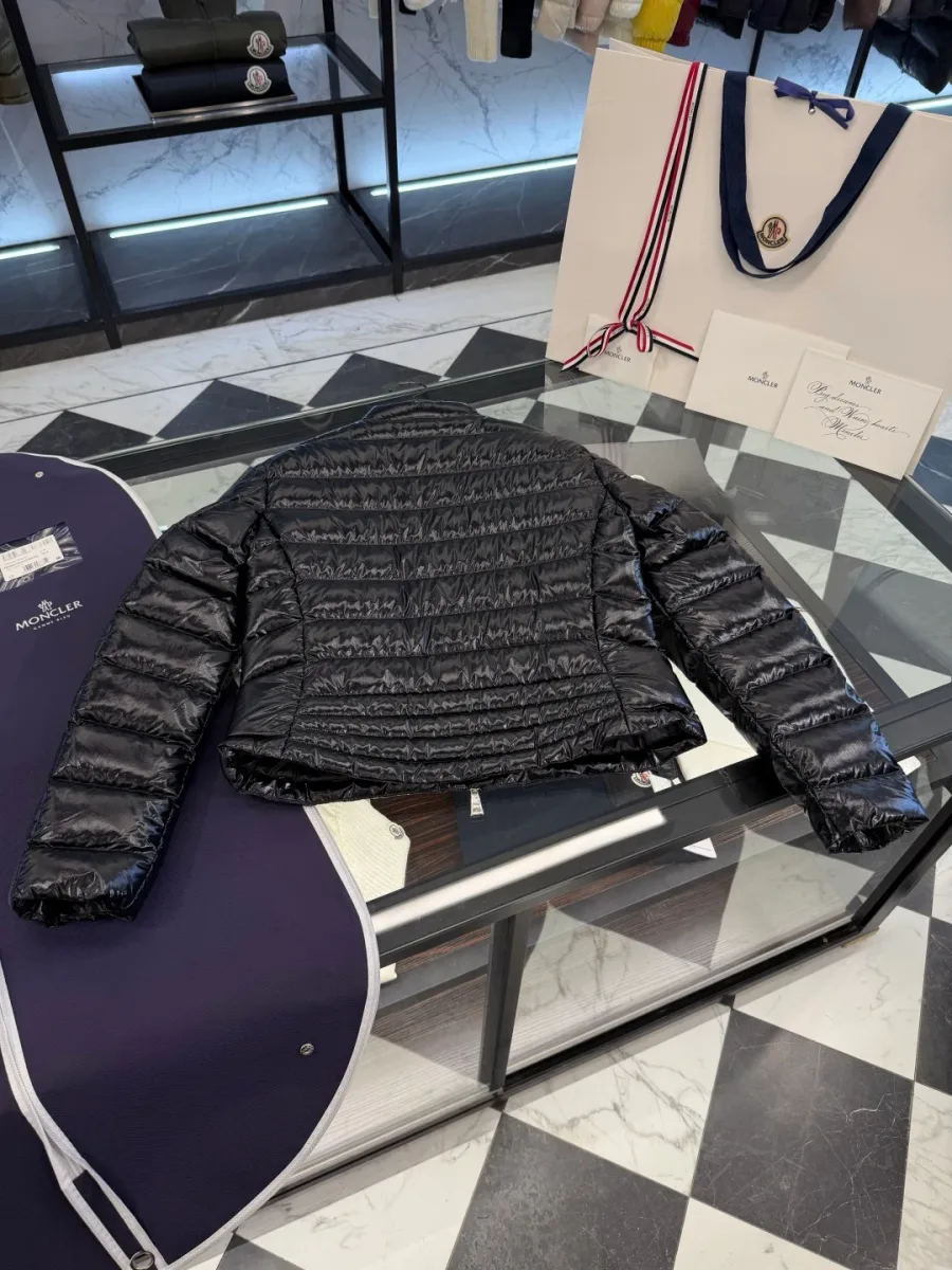 Чёрный пуховик Moncler в расправленном виде на столе, вид со спины