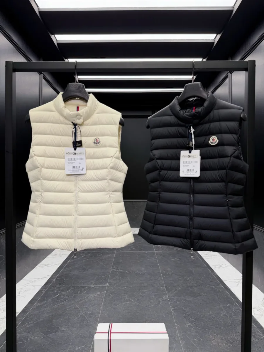 Чёрный и белый женские жилеты Moncler на стойке крупным планом