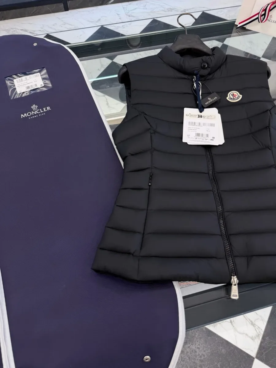 Чёрный пуховый жилет и синий чехол для хранения Moncler, вид сверху