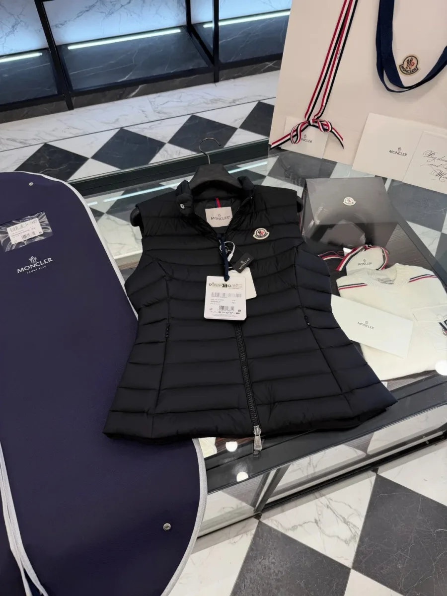 Стеганый жилет Moncler чёрного цвета на стеклянном столе с чехлом