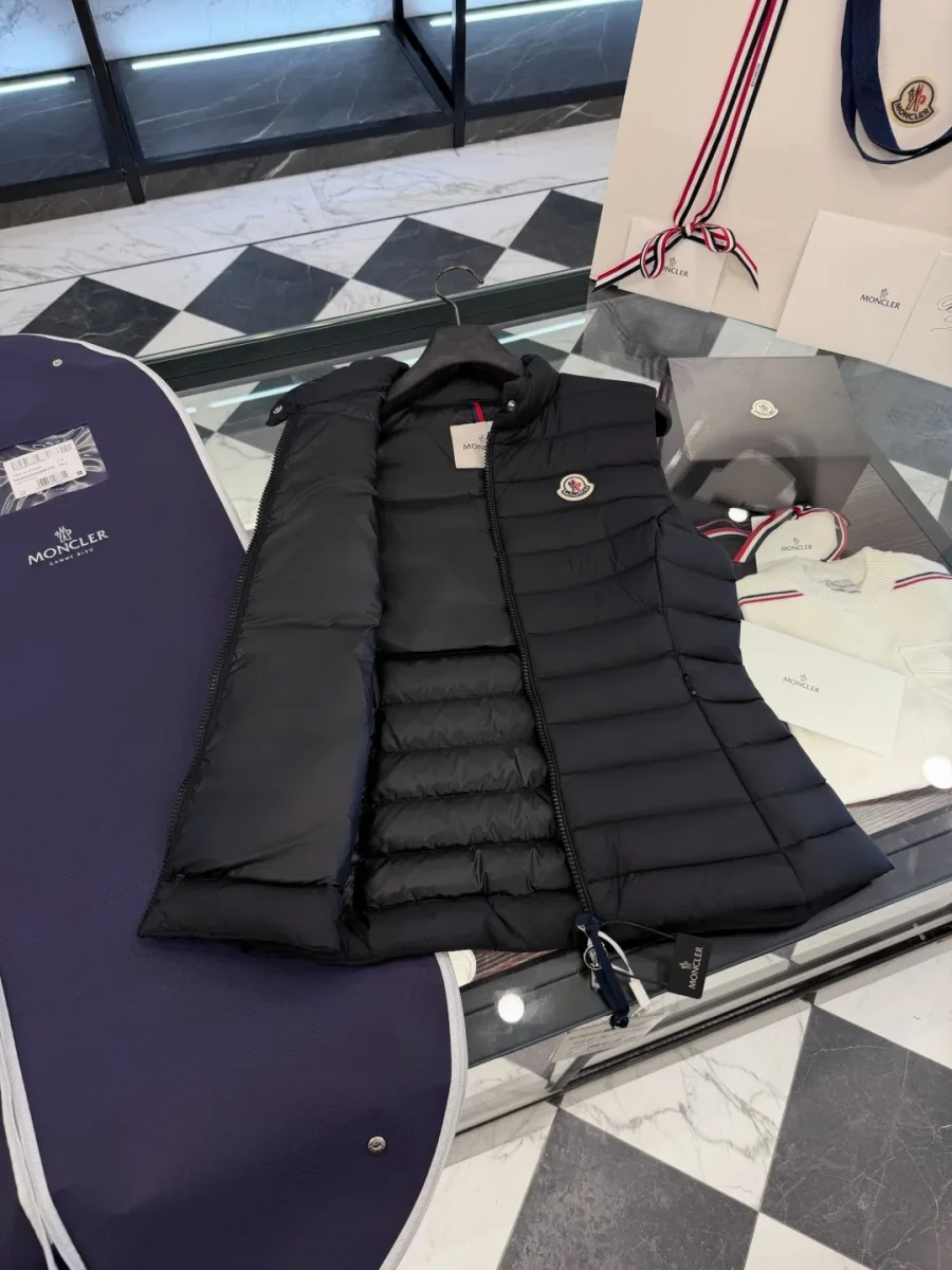 Чёрный жилет Moncler с расстёгнутой молнией на стеклянной витрине