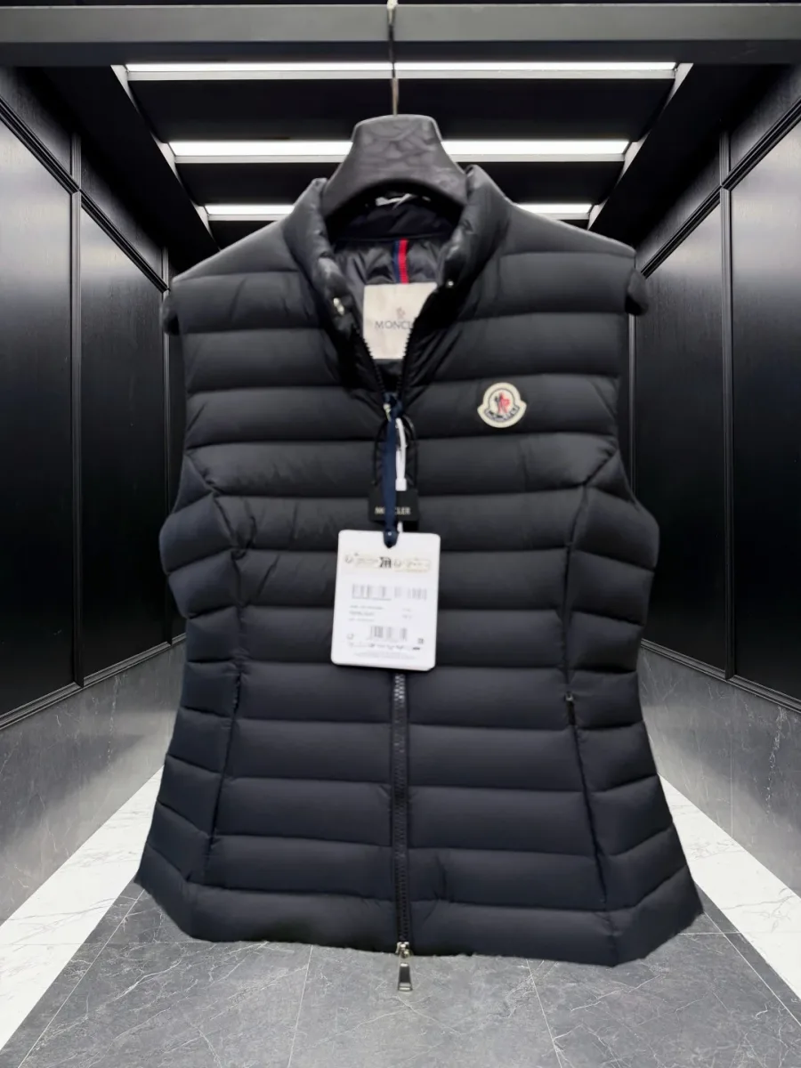 Фронтальный вид чёрного стеганого пухового жилета Moncler на вешалке
