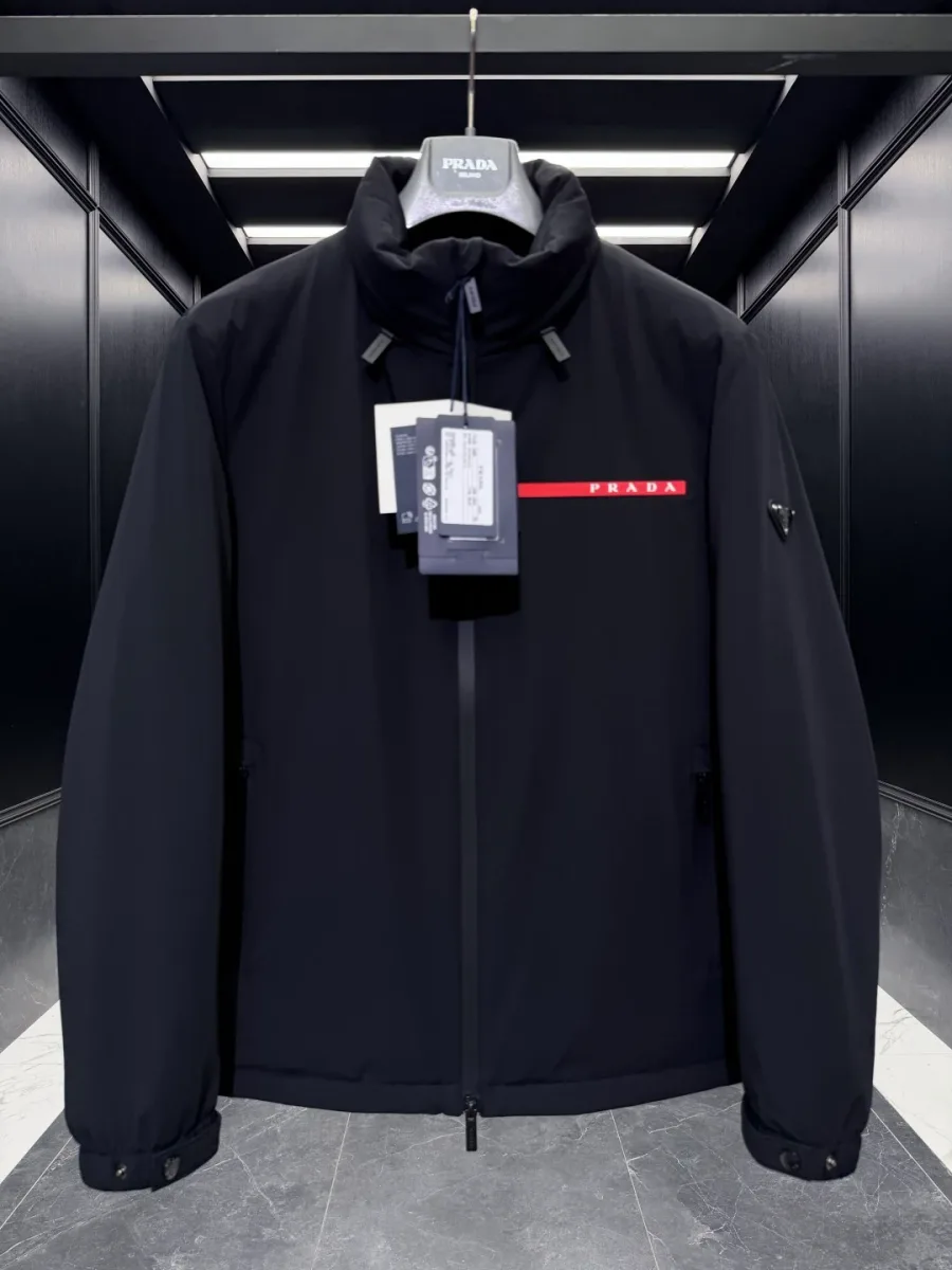 Чёрная куртка Prada Linea Rossa крупным планом спереди, воротник-стойка и треугольный шильдик на рукаве