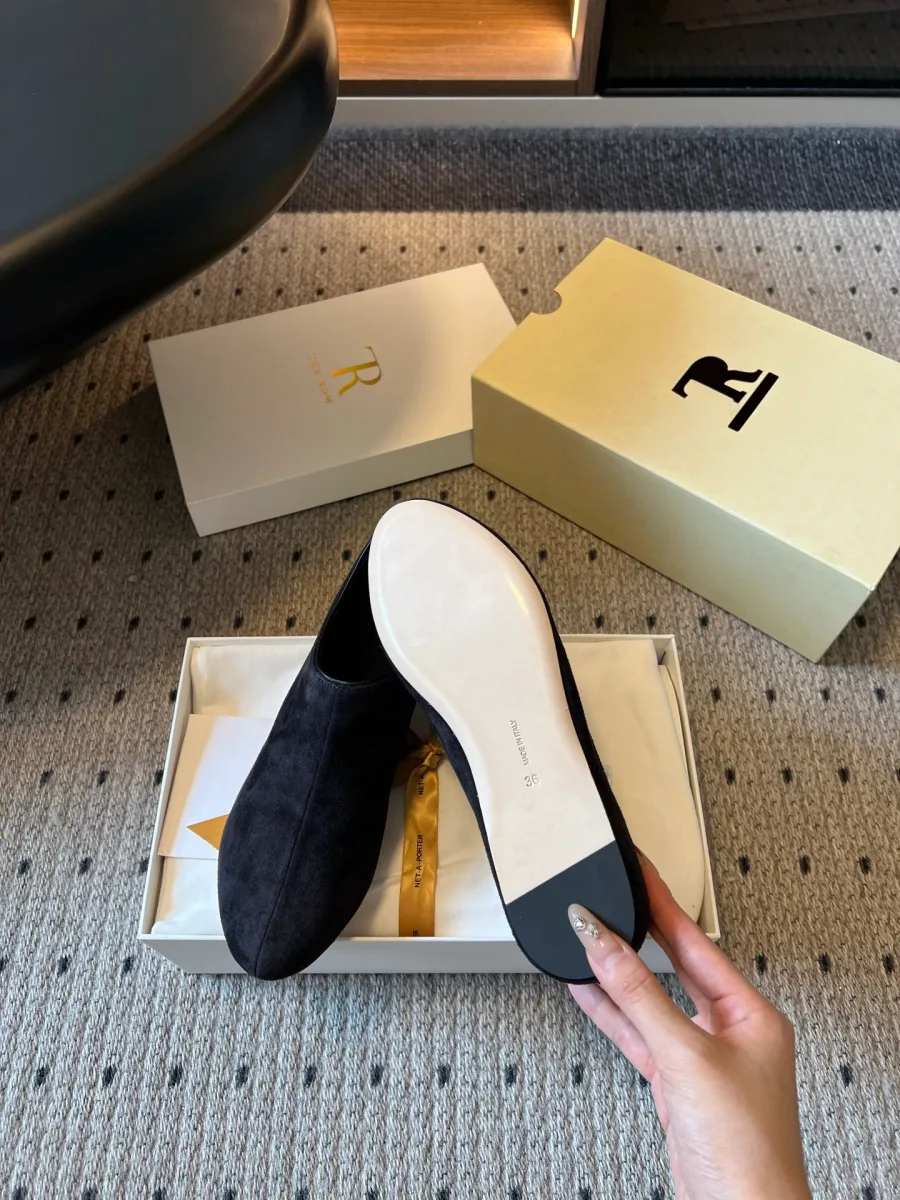 Чёрная туфля с демонстрацией бежевой кожаной подошвы на фоне упаковки