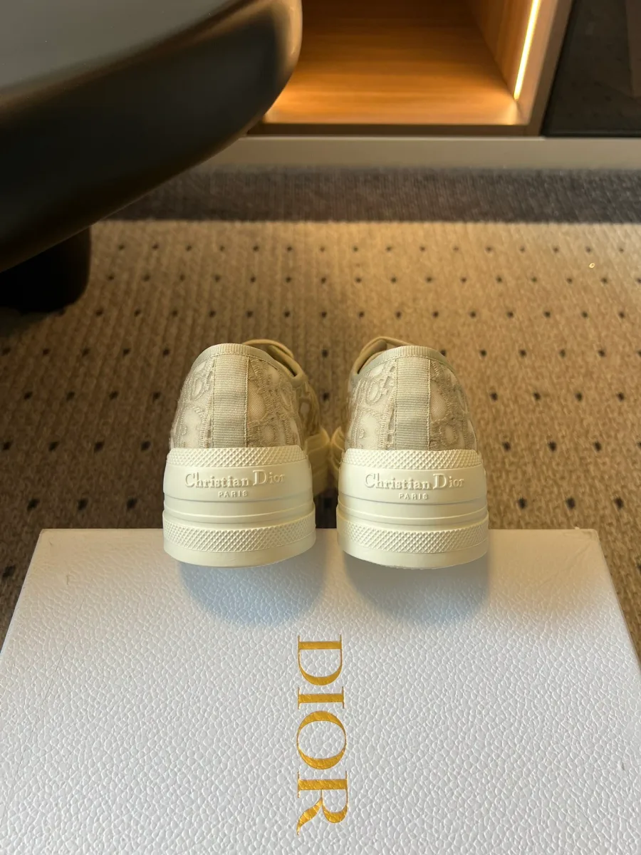 Задняя часть бежевых кед с рельефной надписью Christian Dior на пятке