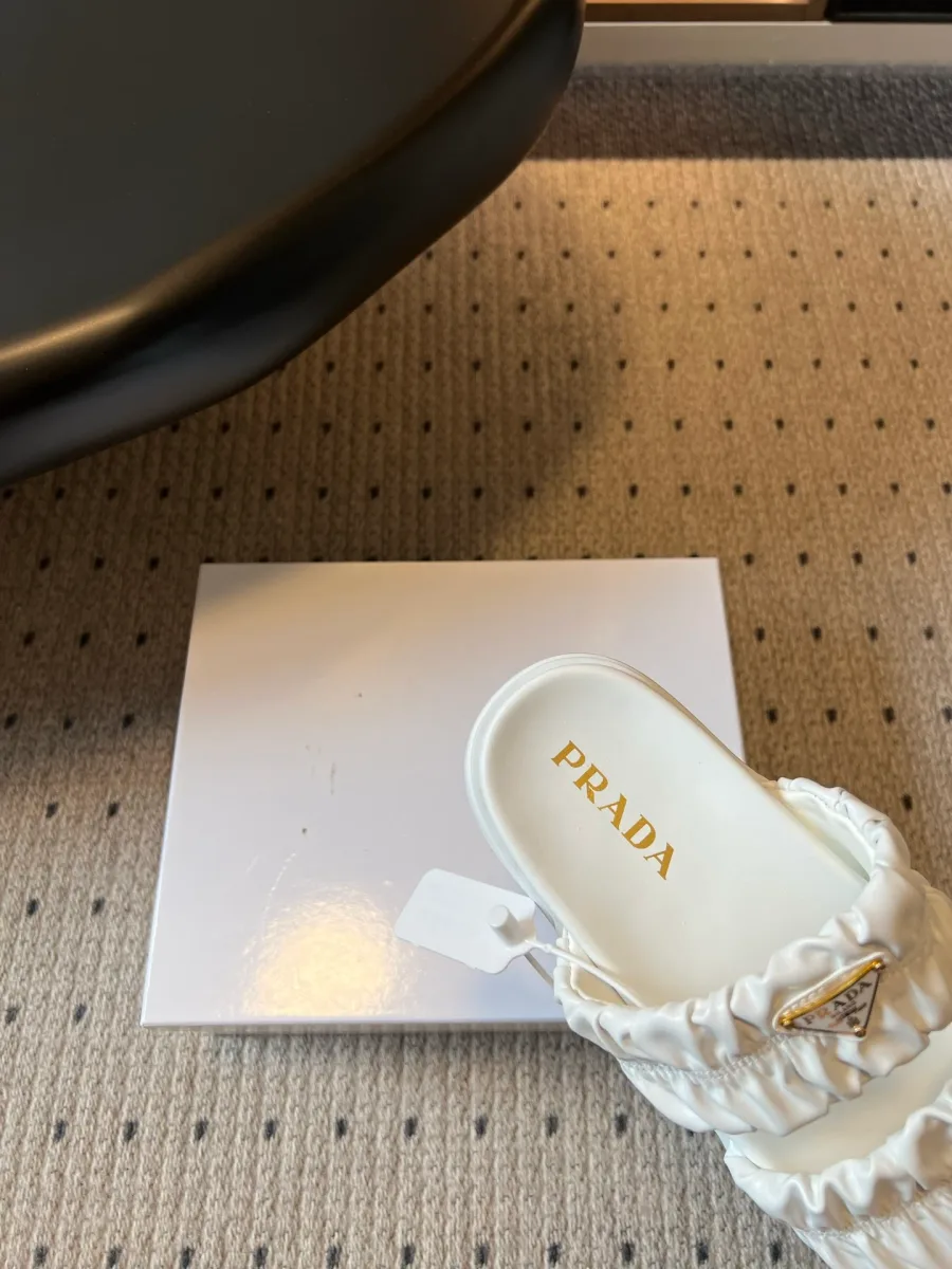 Крупный план анатомической стельки шлепанца с золотистым логотипом Prada