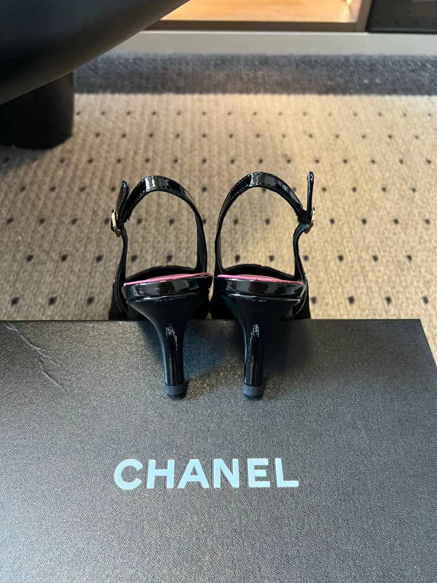 Вид сзади на пару чёрных слингбэков и каблуки на коробке с логотипом Chanel
