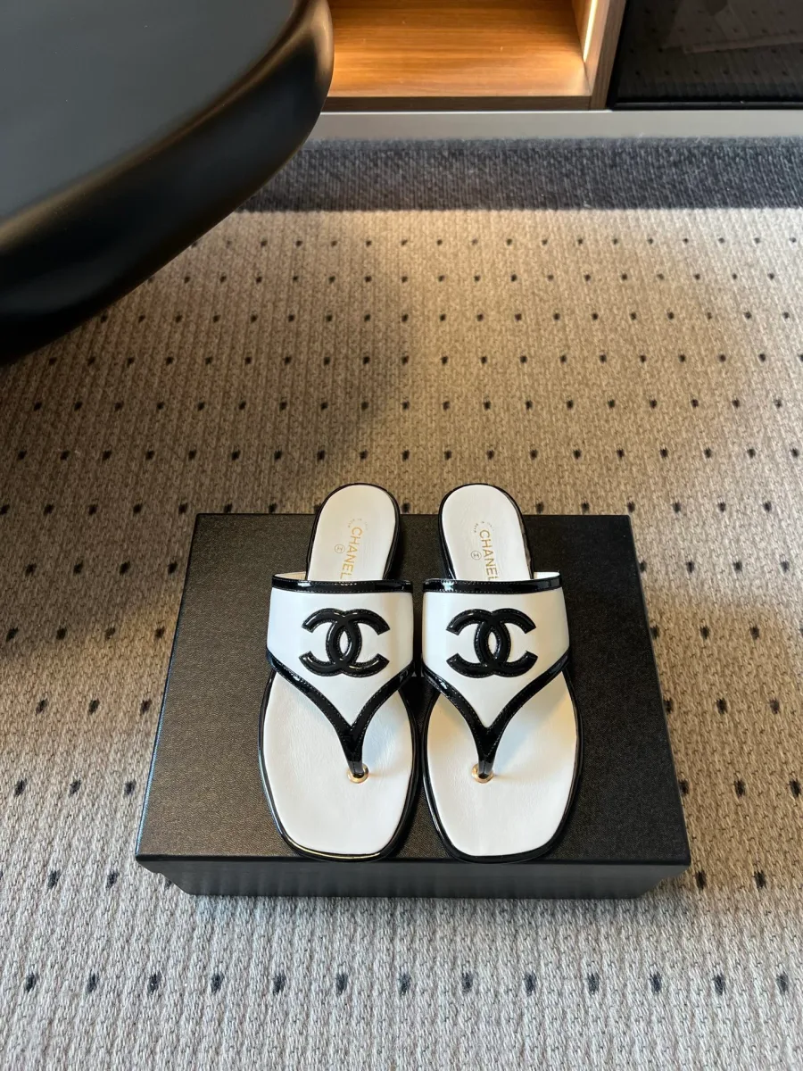 Белые кожаные шлепанцы Chanel через палец с черным логотипом CC, вид сверху на коробке