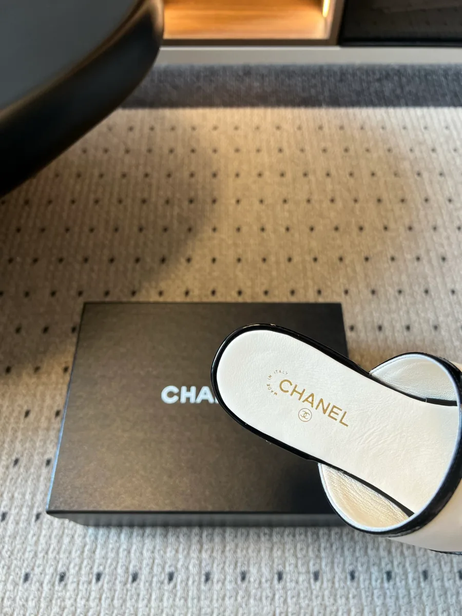 Кожаная стелька белого шлепанца Chanel с тиснением логотипа крупным планом