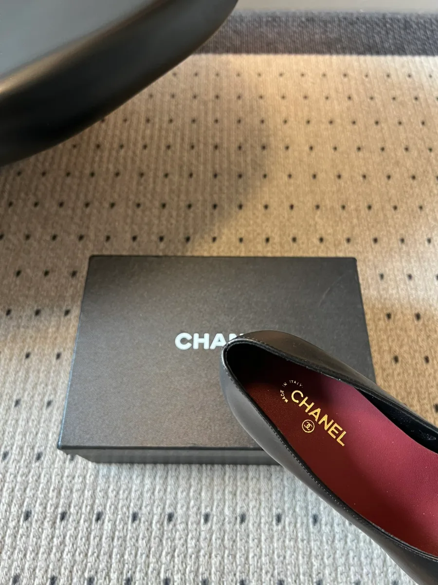 Крупный план бордовой кожаной стельки с золотистым логотипом Chanel
