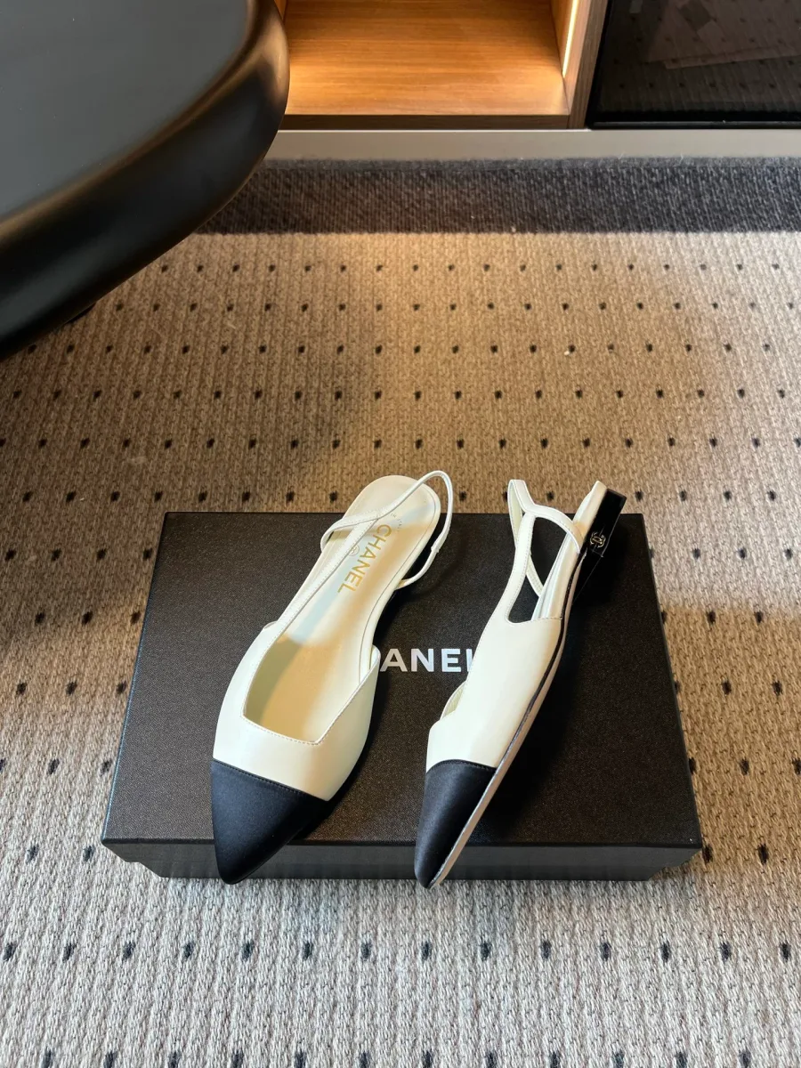 Пара бежево-чёрных кожаных слингбэков на коробке Chanel, ракурс сбоку
