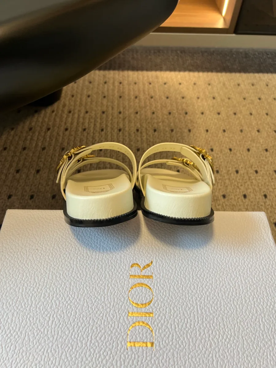 Вид сзади на пару белых шлепанцев на фирменной коробке Dior