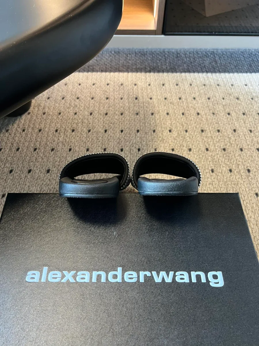 Вид сзади на шлёпанцы на чёрной фирменной коробке Alexander Wang