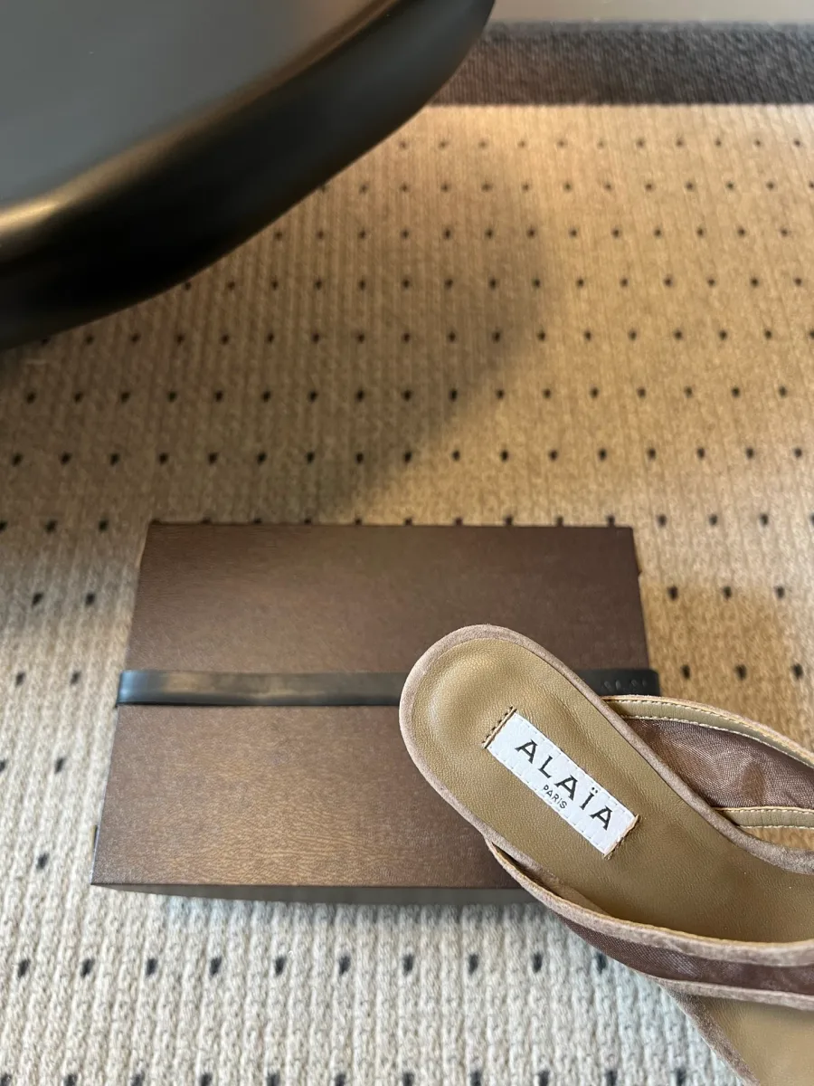 Крупный план кожаной стельки шлепанца с контрастной нашивкой логотипа Alaia Paris