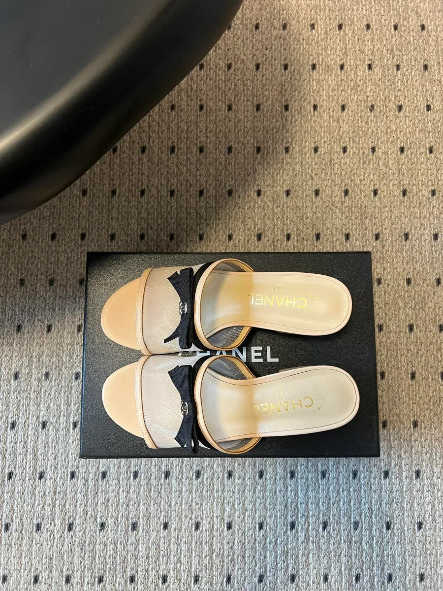 Пара бежевых мюлей с бантами, вид на стельки с логотипом