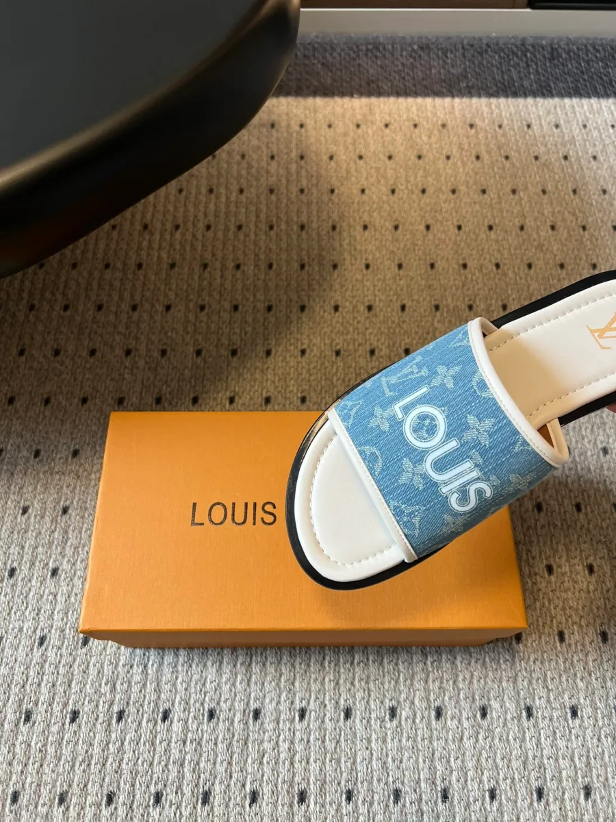 Крупный план широкого ремешка шлёпанца с надписью Louis и узором Monogram
