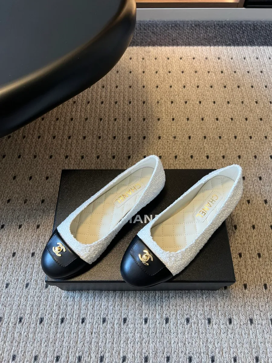 Белые твидовые балетки с контрастным чёрным носком на коробке Chanel, ракурс три четверти