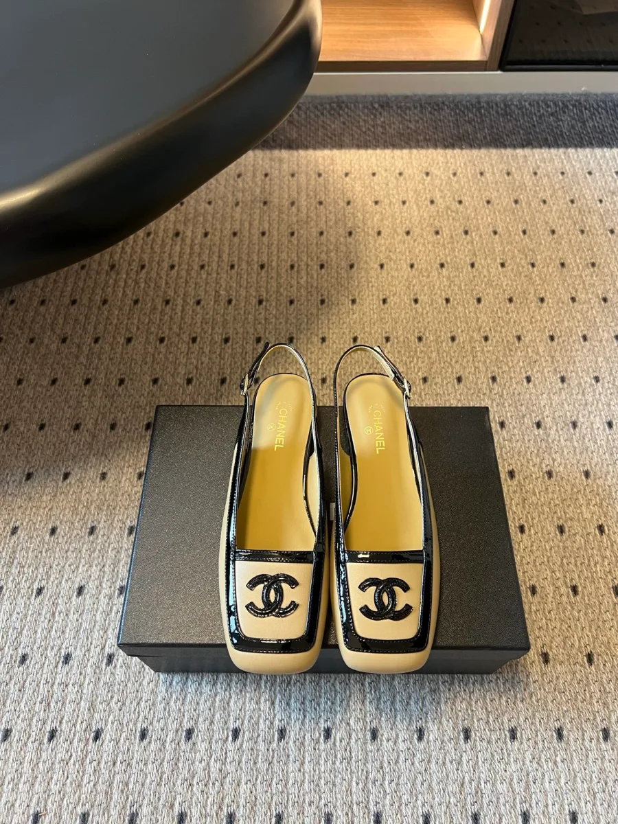 Бежевые кожаные слингбэки Chanel с чёрным кантом, вид спереди сверху на обувной коробке