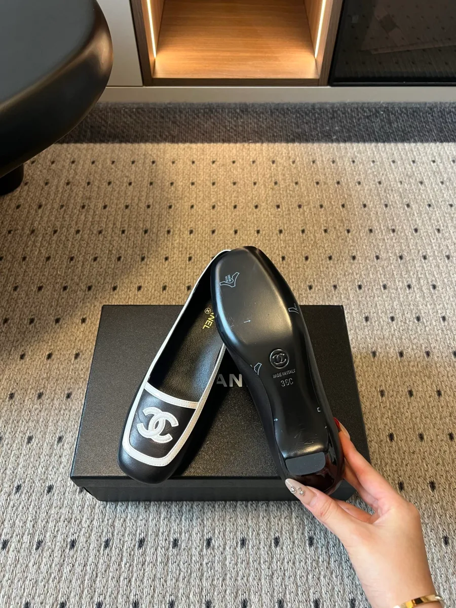Чёрные туфли Chanel с белой отделкой, демонстрация кожаной подошвы