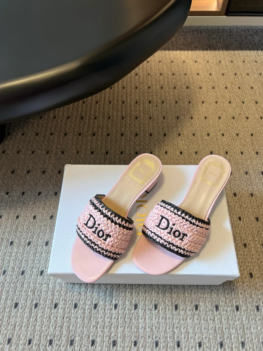 Розовые плетёные шлепанцы с вышивкой Dior, ракурс три четверти на коробке
