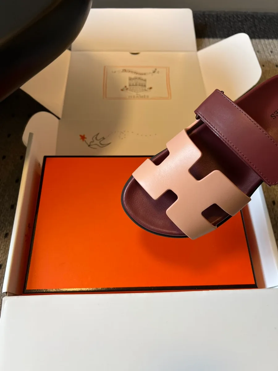 Деталь мыска шлепанца Hermes Chypre с розовой вставкой в форме буквы H