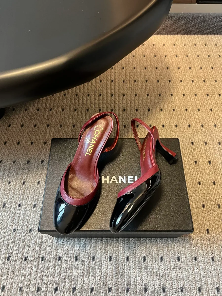 Пара лакированных туфель slingback чёрного и бордового цветов на обувной коробке