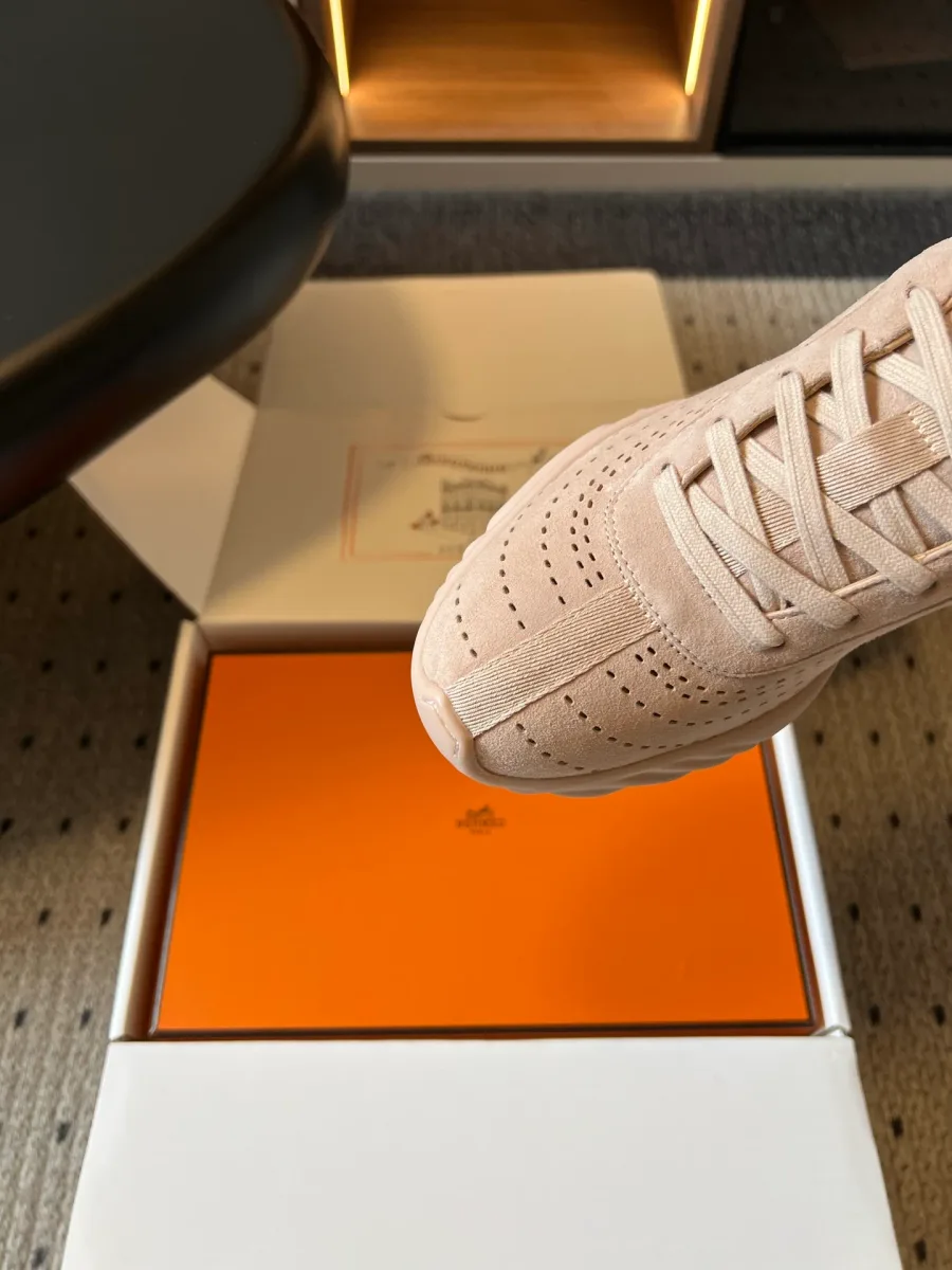 Крупный план перфорированного мыска и шнуровки бежевого кроссовка