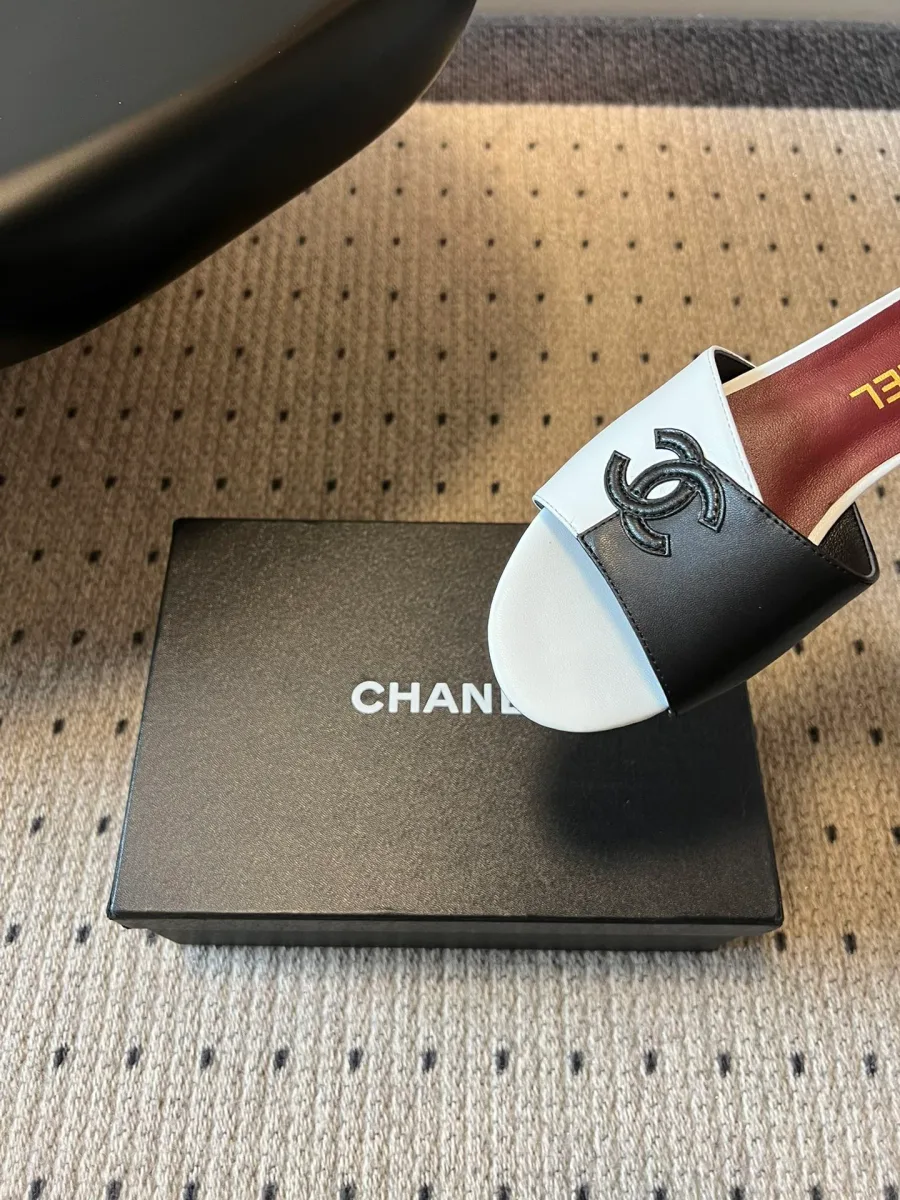 Крупный план двухцветного кожаного ремешка шлёпанцев Chanel с эмблемой CC