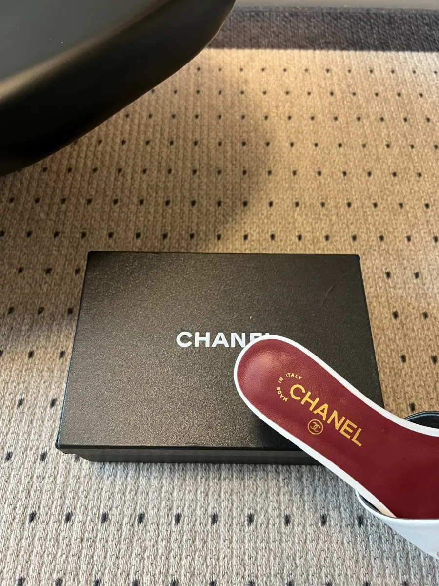 Крупный план бордовой кожаной стельки шлёпанцев с золотистым логотипом Chanel