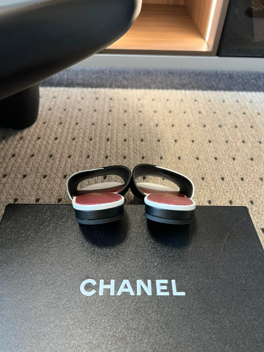 Чёрно-белые шлёпанцы Chanel на фирменной коробке, вид со стороны пятки