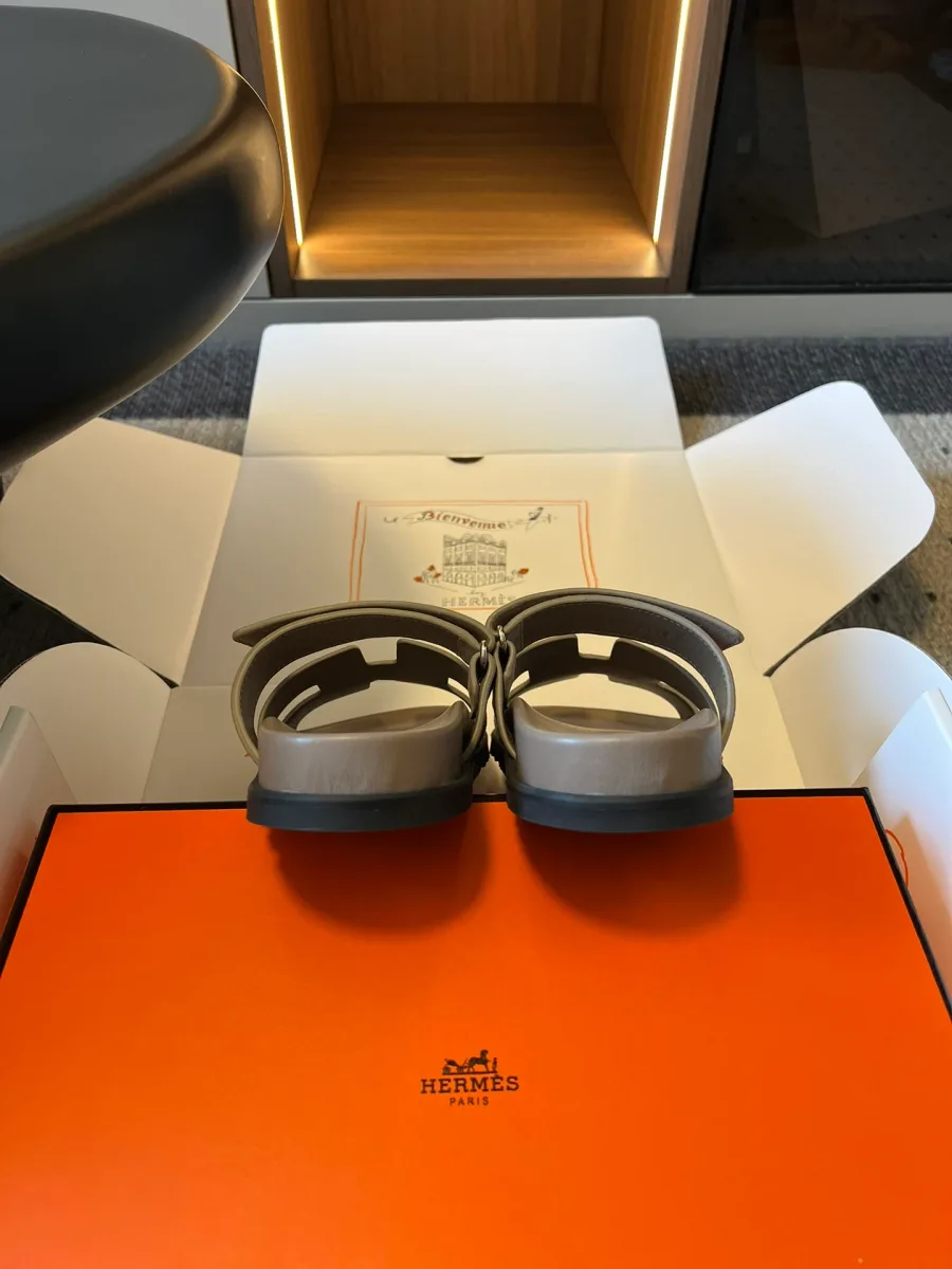 Вид сзади на пяточную часть пары замшевых шлёпанцев на коробке