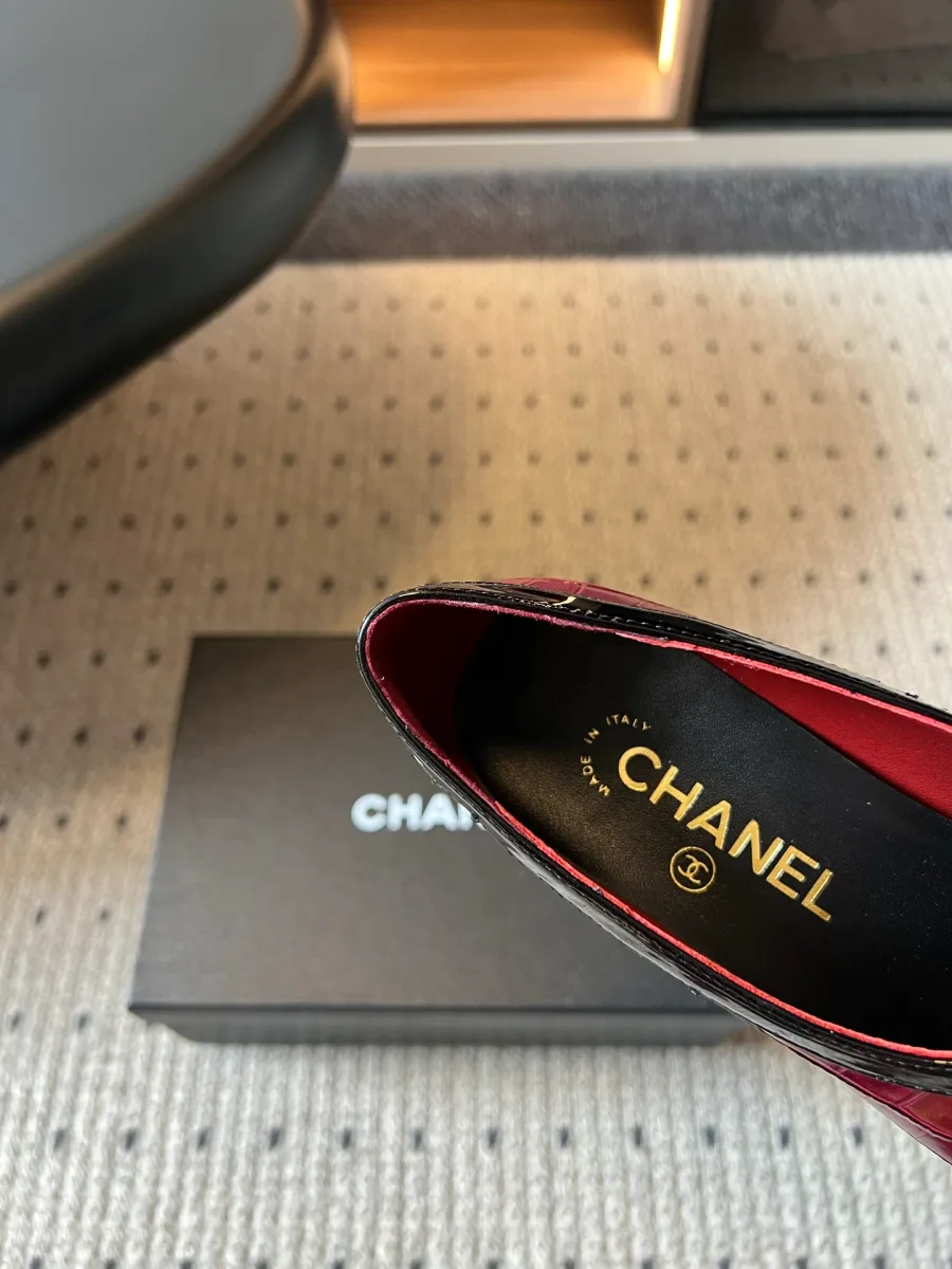 Крупный план стельки с золотистым логотипом Chanel внутри бордовой туфли